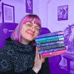 Fanny kuschelt mit dem Stapel ihrer Bücher (Stand 2025). Von oben nach unten: Ingenio 1, Ingenio 2, Movitae, Die Farbe der Vernunft, Der Seerosenzirkel, Götterhain, That fucking Bet