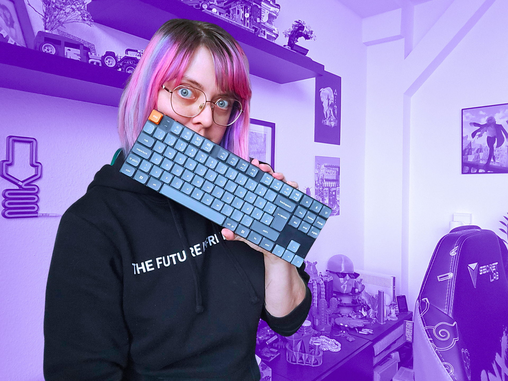 Fanny hält sich ihre Tastatur halb vors Gesicht und guckt dahinter hervor