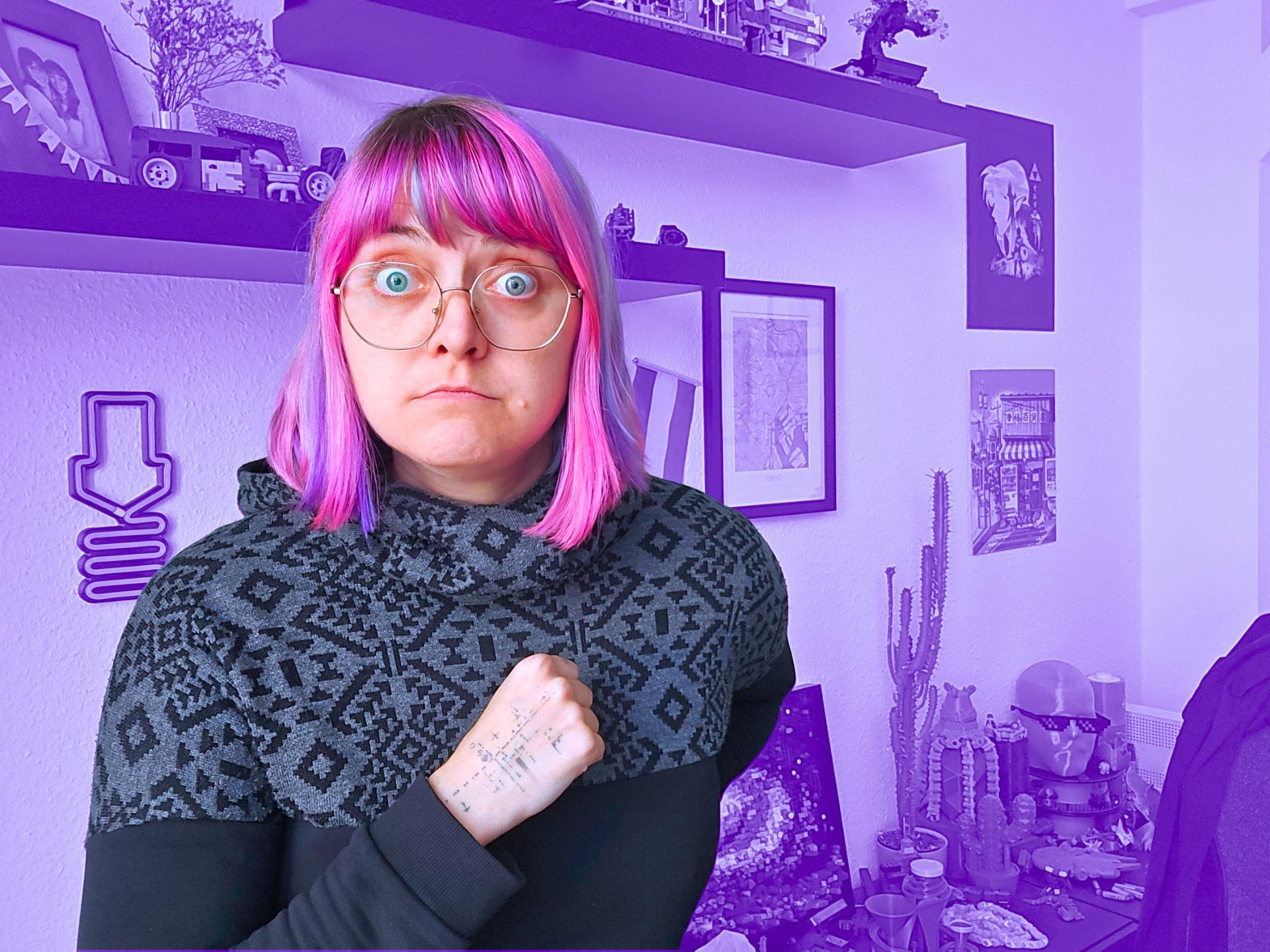 Fanny guckt ratlos überrascht in die Kamera. Der Hintergund (ihr Zimmer) ist lila eingefärbt.